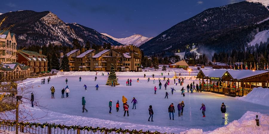 Skiers enjoying a sunny day on a snowy Colorado mountain